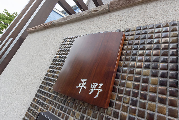 エントランスは家の顔とも言えますので、細部にまでこだわりました。訪れる人誰もが見る表札にはトップコートで仕上げた木製のものをチョイスしました。自然の恵みを受けて育った銘木に自分の名前を刻む。その手触りやあたたかな風合いは格別です。 hirano01-05